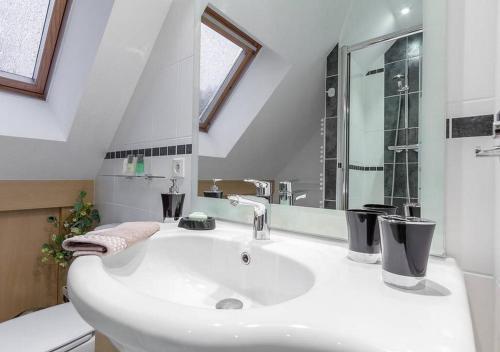 a white bathroom with a sink and a mirror at Le Clos de Kerhouil in Sainte Anne d'Auray 