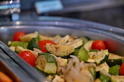 a pan of vegetables with chicken and tomatoes at Champagne Castle Hotel in Champagne Valley