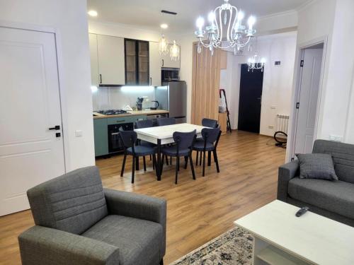 a living room with a table and chairs and a kitchen at Stylish House in Kutaisi