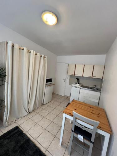 une cuisine avec une table en bois et une table et des chaises dans l'établissement Studio équipé Paris 20e, à Paris