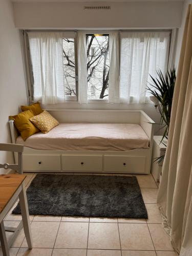 - un siège de fenêtre avec un lit dans une chambre dans l'établissement Studio équipé Paris 20e, à Paris
