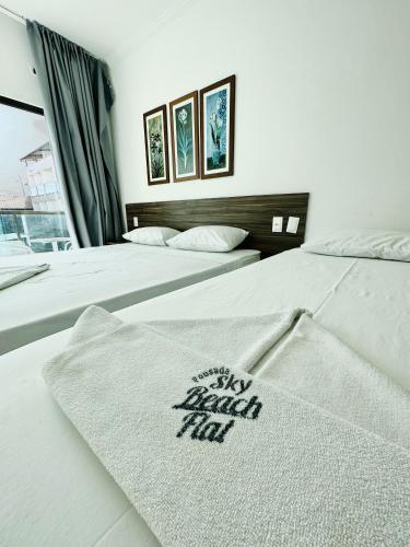 two beds in a hotel room with a blanket on them at Pousada Sky Beach Flat in Porto De Galinhas