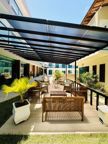 a patio with benches and tables under awning at Pousada Sky Beach Flat in Porto De Galinhas