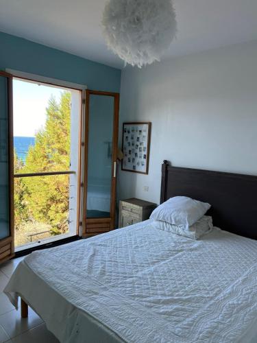 une chambre avec un lit et une grande fenêtre dans l'établissement Maison à 50 mde la plage, pour 10 personnes en Corse du sud,, à Coti-Chiavari