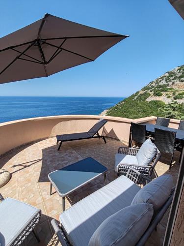 taras z krzesłami i parasolem oraz ocean w obiekcie Villa Contact w Dobrej Vodzie