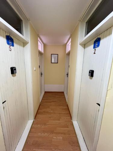 a corridor of a hallway with white doors at Sobe Zoka in Subotica