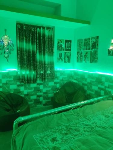 a bedroom with green lights on the wall at Risabya Guest House in Gājol