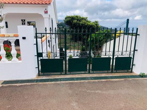 a black gate in front of a white house at House in caniço in Ribeirinha