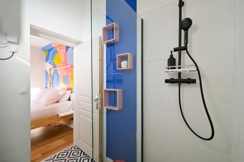 La salle de bains est pourvue d'une douche avec un mur bleu. dans l'établissement La vie en couleurs, au Havre