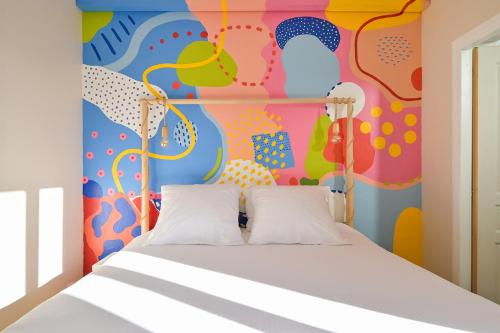 - une chambre avec un lit et un mur coloré dans l'établissement La vie en couleurs, au Havre