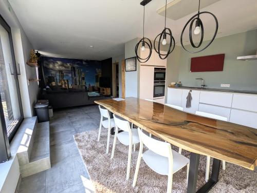 a kitchen with a long wooden table and white chairs at Gasthuis Puytvoet in Sint-Niklaas