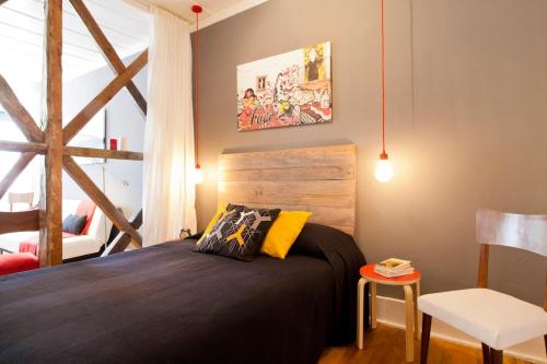 a bedroom with a bed and a table and a chair at Lisbon Sant'Ana Alcantara 2br apart in Lisbon