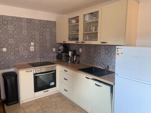 a kitchen with white cabinets and a white refrigerator at Chalupa Krompach in Krompach