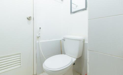 a white bathroom with a toilet and a shower at Eimy's Place at Urban Deca Mandaluyong by RedDoorz in Manila