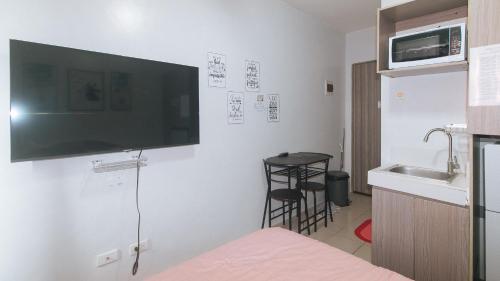 a room with a flat screen tv on the wall at Eimy's Place at Urban Deca Mandaluyong by RedDoorz in Manila
