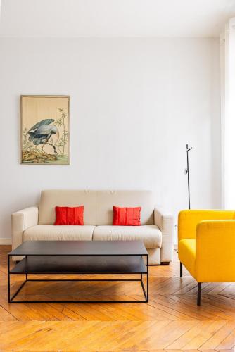 - un salon avec un canapé blanc et des oreillers rouges dans l'établissement 4P apartment #Jardin Luxembourg#Montparnasse#Paris 6, à Paris