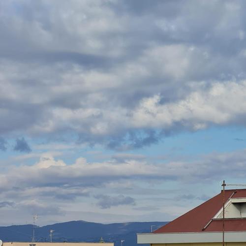 a cloudy sky with a building and a house at Grace's Home in Ladispoli