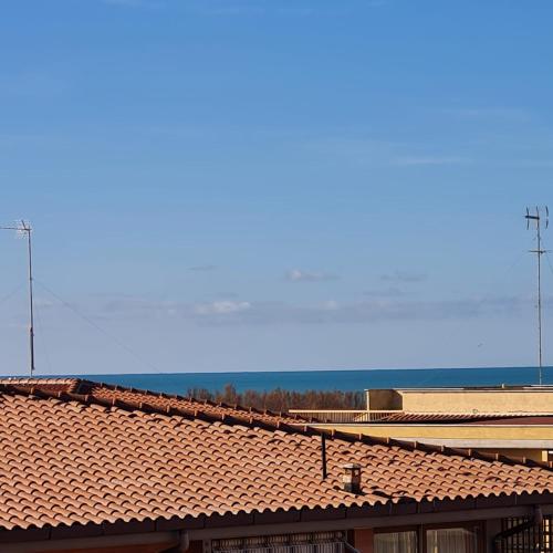 a tile roof of a building with the ocean in the background at Grace's Home in Ladispoli