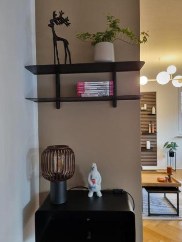a room with three shelves on a wall with a lamp at Im Zentrum von Leverkusen, helle 3-Zimmerwohnung 80 m2 in Leverkusen