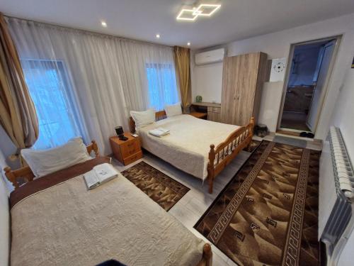a small bedroom with two beds and a couch at Guest House Rosenovi in Lyaskovo