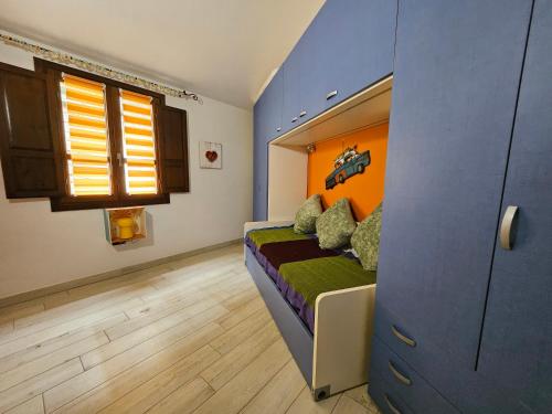 a bedroom with a bed with an orange and blue wall at Sa Mirada Apartments in Villasimius