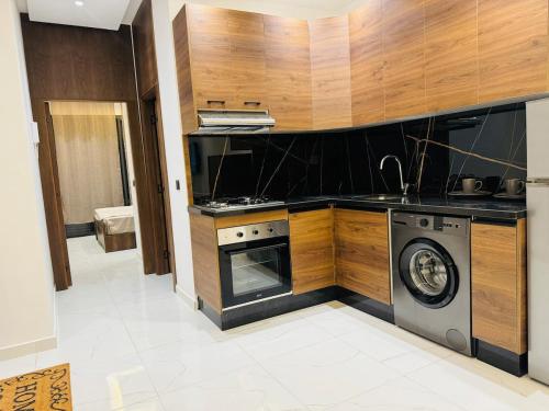 a kitchen with a stove and a washing machine at Heart of Paradise in Mehdia 36 in Kenitra