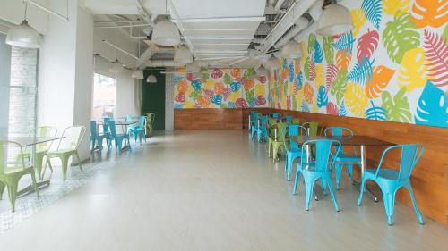 a dining room with tables and chairs and a colorful wall at Eimy's Place at Urban Deca Mandaluyong by RedDoorz in Manila
