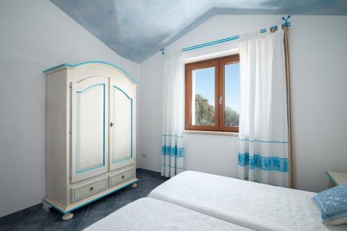 a bedroom with a bed and a dresser and a window at Residence Solaria in Budoni
