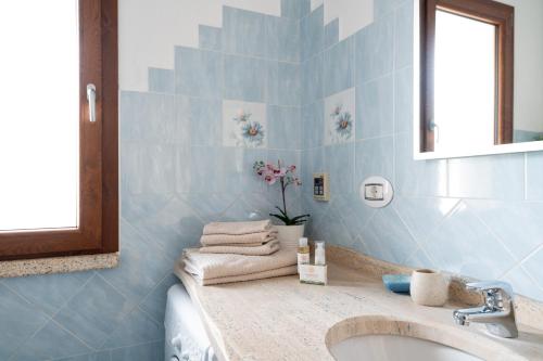 a blue bathroom with a sink and a mirror at Residence Solaria in Budoni