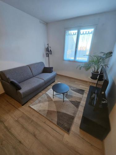 un soggiorno con un divano e un tavolo di Appartement cosy proche du Mont-Dore a Laqueuille