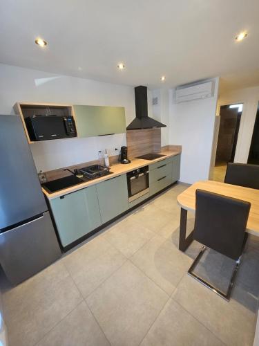 una cucina con un tavolo e una stufa forno superiore di Appartement cosy proche du Mont-Dore a Laqueuille