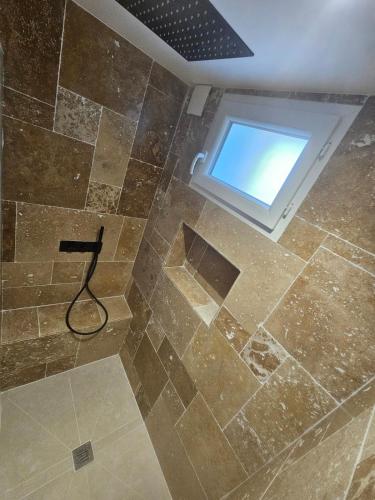 une salle de bain avec douche et fenêtre dans l'établissement Appartement cosy proche du Mont-Dore, à Laqueuille