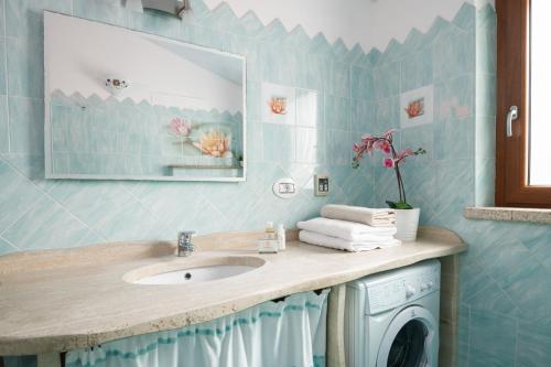 a bathroom with a sink and a washing machine at Residence Solaria in Budoni