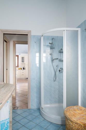 a bathroom with a shower with blue tiles at Residence Solaria in Budoni