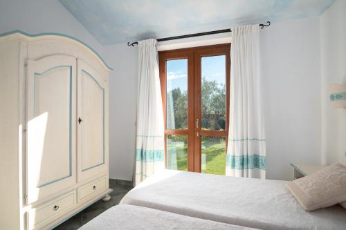 a bedroom with a bed and a window at Residence Solaria in Budoni