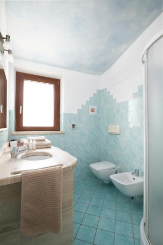 a bathroom with a sink and a tub and a toilet at Residence Solaria in Budoni