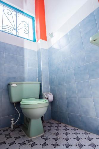 a bathroom with a green toilet and a window at Hotel Kasa Dokari in Honda