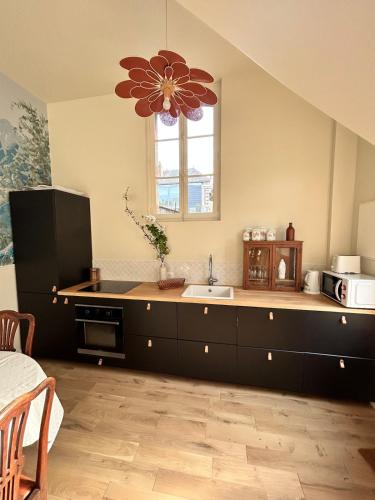 d'une cuisine avec un comptoir, un évier et une fenêtre. dans l'établissement Jolie maison avec jardin proche du centre ville mais au calme comme à la campagne, à Tours