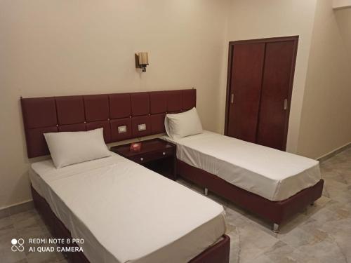 two beds in a hotel room with two beds sidx sidx sidx at Red Sea Hotel in Būr Tawfīq