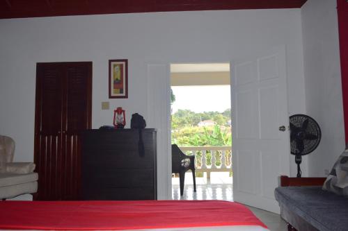 ein Schlafzimmer mit Bett und Blick auf einen Balkon in der Unterkunft Harriott Heights in Mandeville