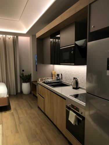 a kitchen with a sink and a stove top oven at The City Landing Apartments At The Diamond in City in Accra