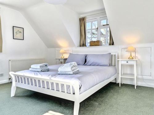 une chambre avec un lit blanc avec des serviettes dessus dans l'établissement Tranquil 2-Bed Nature Cottage with Free Parking, à Newick