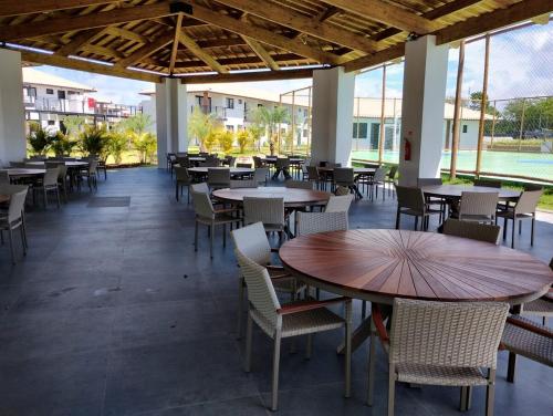 プライア・ド・フォルテにあるVilage Dove Praia do Forteのテーブルと椅子と窓がある空のレストラン