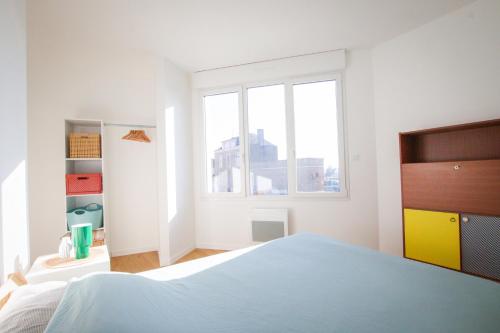 a white bedroom with a bed and a window at Appartement rez de chaussée à Beaupréau en Mauges in Beaupréau