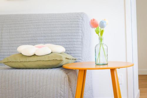 a vase of flowers sitting on a pillow next to a table at Appartement rez de chaussée à Beaupréau en Mauges in Beaupréau