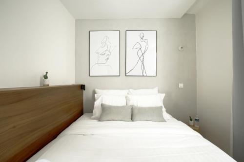 - une chambre dotée d'un lit avec deux dessins sur le mur dans l'établissement Stay in a Designer Apartment with Private Terrace, à Paris