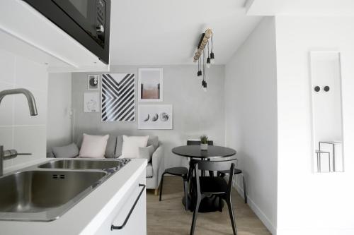 - une cuisine avec un évier et une table dans l'établissement Stay in a Designer Apartment with Private Terrace, à Paris