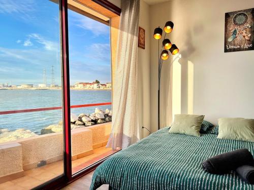 une chambre avec une fenêtre avec vue sur l'océan dans l'établissement Voile de Mer - 2 Studios Bord de Mer, 2 SDB, CLIM, 5 personnes, à Fos-sur-Mer