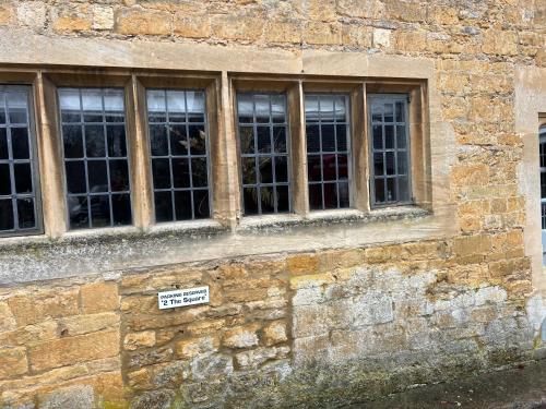 a brick building with windows and a sign on it at Fordview Cottage is full of Cotwolds Charm in Upper Slaughter