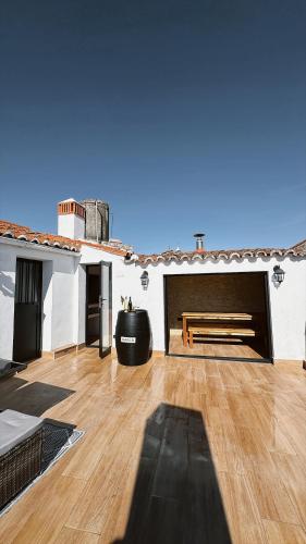 a large living room with a wooden floor and a bench at La Casa del Escudo in Trujillo